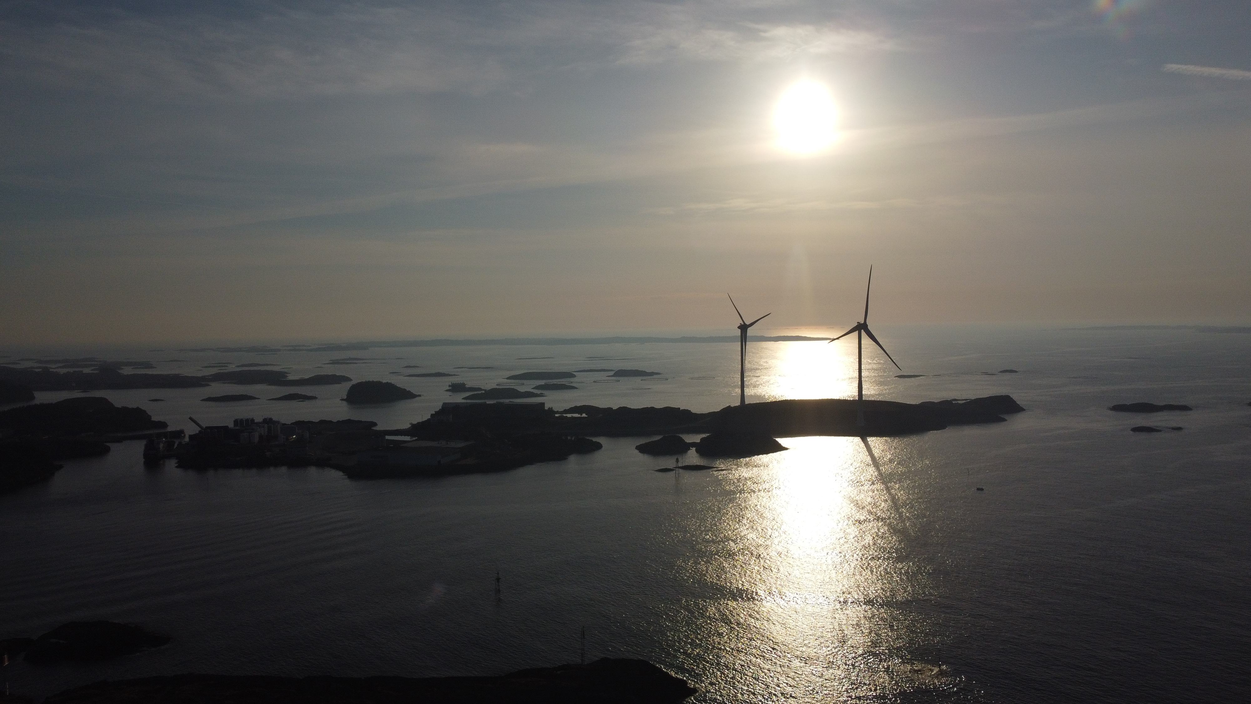 Offshore wind turbines at sunset over Norwegian coastline